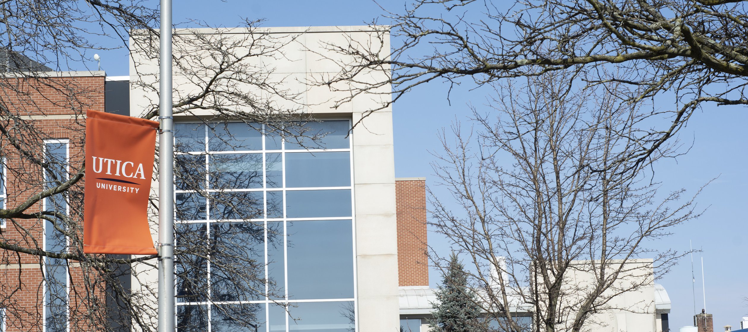 Orange University Banner outside Romano Hall.