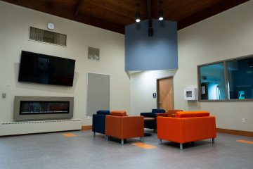 Chairs, fireplace, and television in the new Wilcox Center.