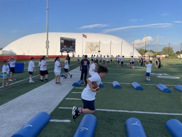 Players run thruogh obstacles on the field as part of A Call to Men Gootball Camp.