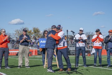 Hugs on the football field during the dedication of ABM Field.