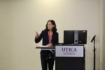 Dean Sharon Wise at a lectern, instructng students taking part in the AMC10/12 Mathematics Competition.