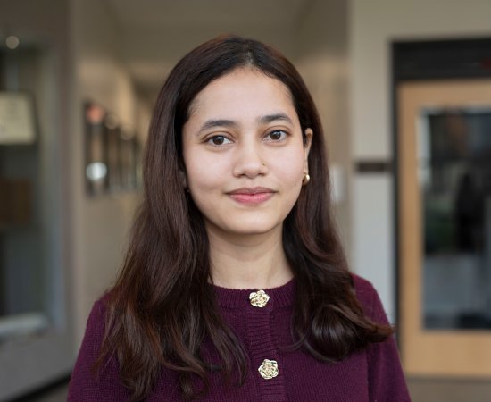 Pratiksha Bista, in purple top and lon gdark hair, smiles at camera.