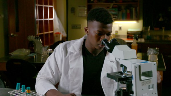 Dr Ivan Iton '21 looks through microscope