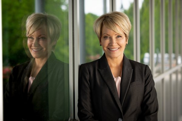 President Laura Casamento stands by a glass window, with her reflection showing in the glass next to her.