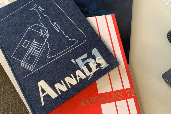 Copies of the Utica College 1951, 1972 and 1993 yearbooks stacked atop each other on a desk.