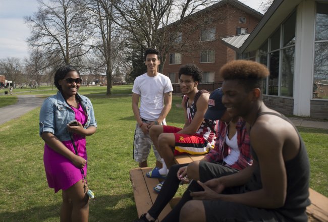 Students laughing at campus picnic tables in Spring 068