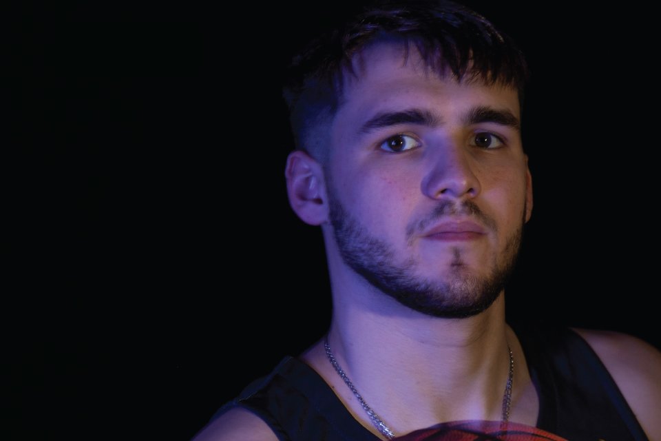 Portrait of Damian Call '24, in jersey holding basketball.