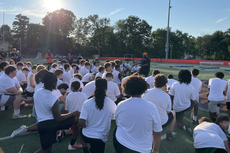 Players kneel on the field for A Call to Men Football Camp