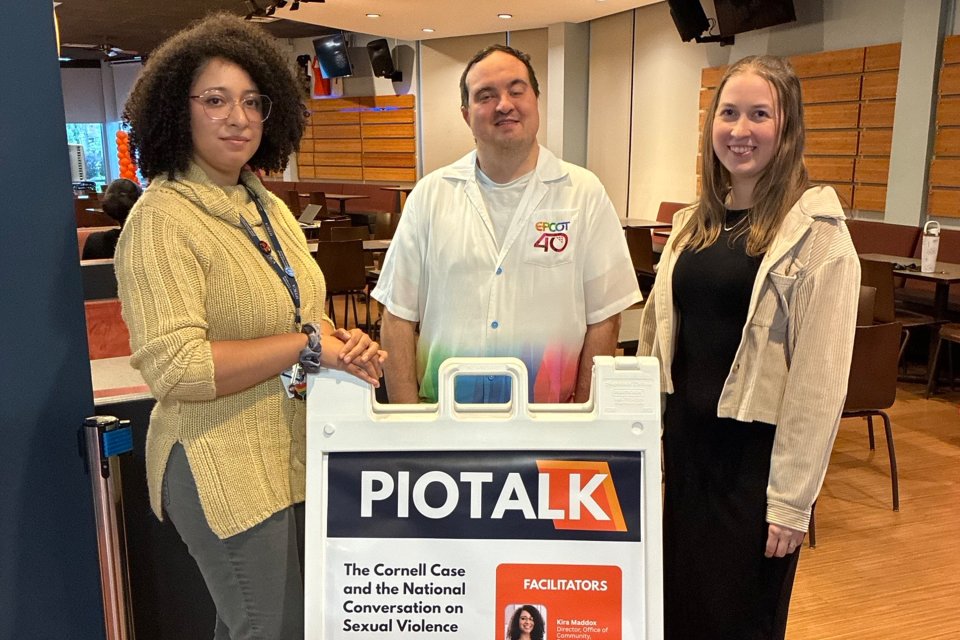 Kira Maddox, Kyle Wilson, and Alicia Reed stand by a sign for PioTalk.